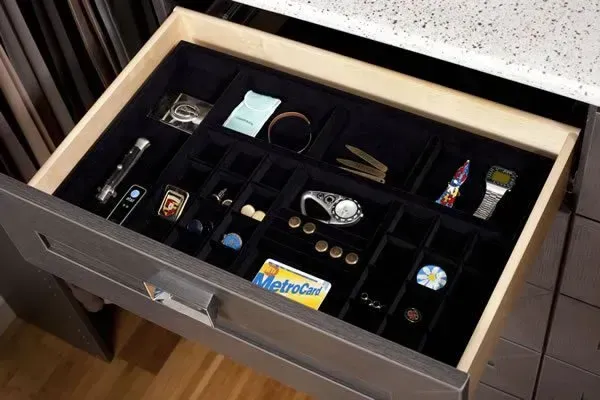 Open drawer with organized compartments holding small items and accessories