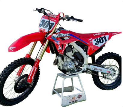 Red Honda motocross dirt bike with number 301 on a stand, isolated on white background