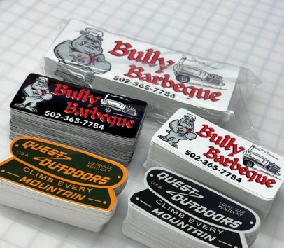 Assorted Bully Barbeque takeout tins with red, black, and white labels on a table
