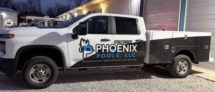 Phoenix Pools LLC service truck parked beside a building at dusk
