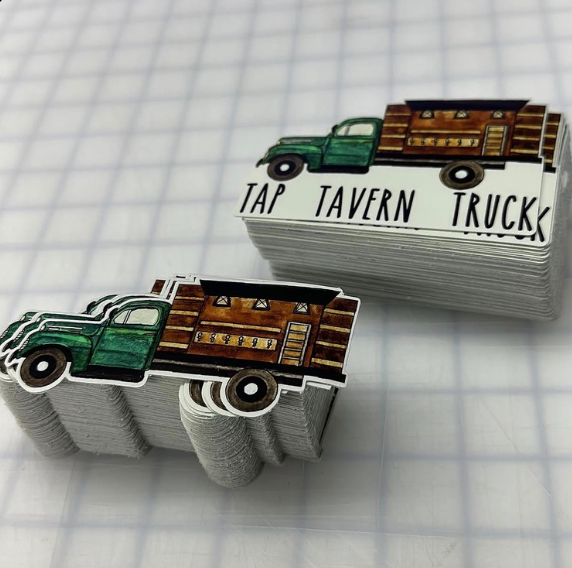 Miniature green tap tavern truck sculptures on a graph paper background