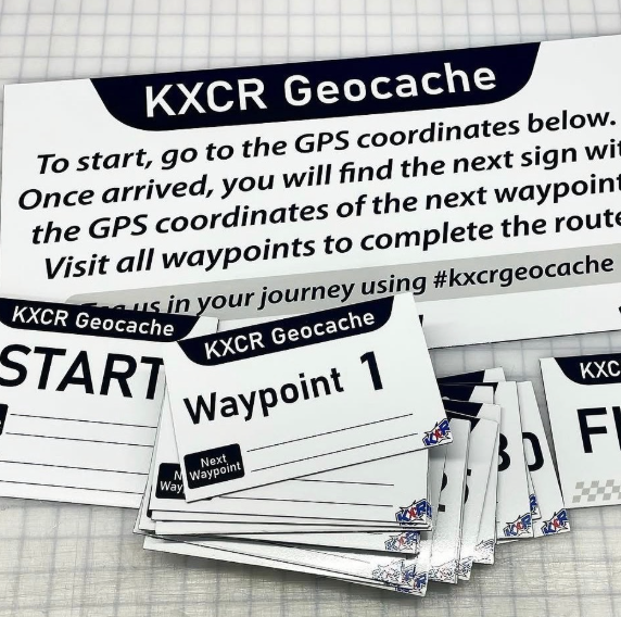 KXCR Geocache guide cards and waypoint signs on a table, with start and waypoint 1 visible