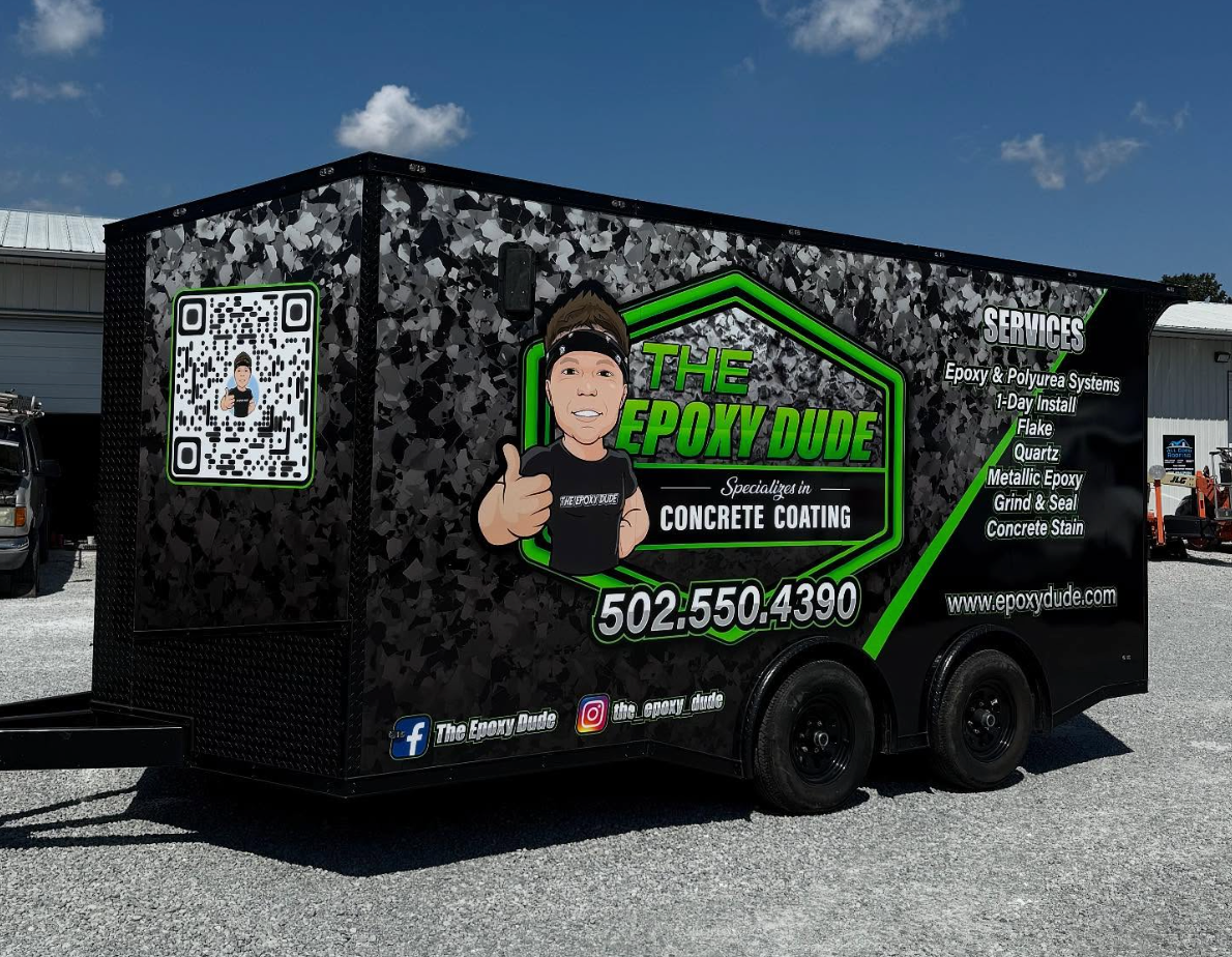 Black trailer with junk removal branding, QR code, and large green logo parked outdoors on gravel.