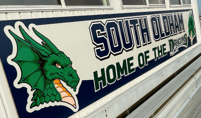 South Beloit school sign with green dragon mascot and “Home of the Bucs” text