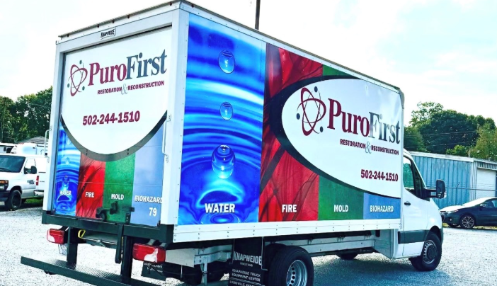 PuroFirst disaster response truck with water, fire, mold, and asbestos service graphics parked outdoors