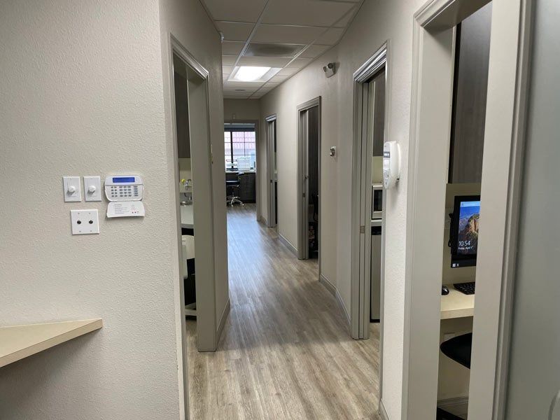 Office hallway with open doors, light wood floor, and a view into rooms beyond
