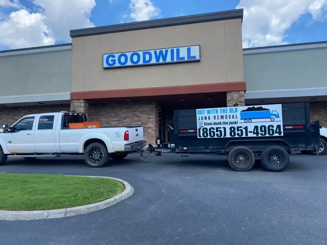 White pickup and black trailer parked outside a Goodwill store entrance