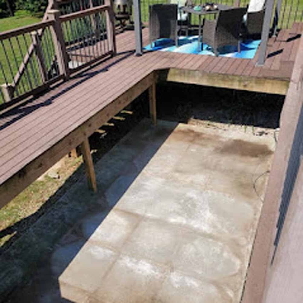 Backyard deck with a raised patio, wooden walkway, and concrete space below