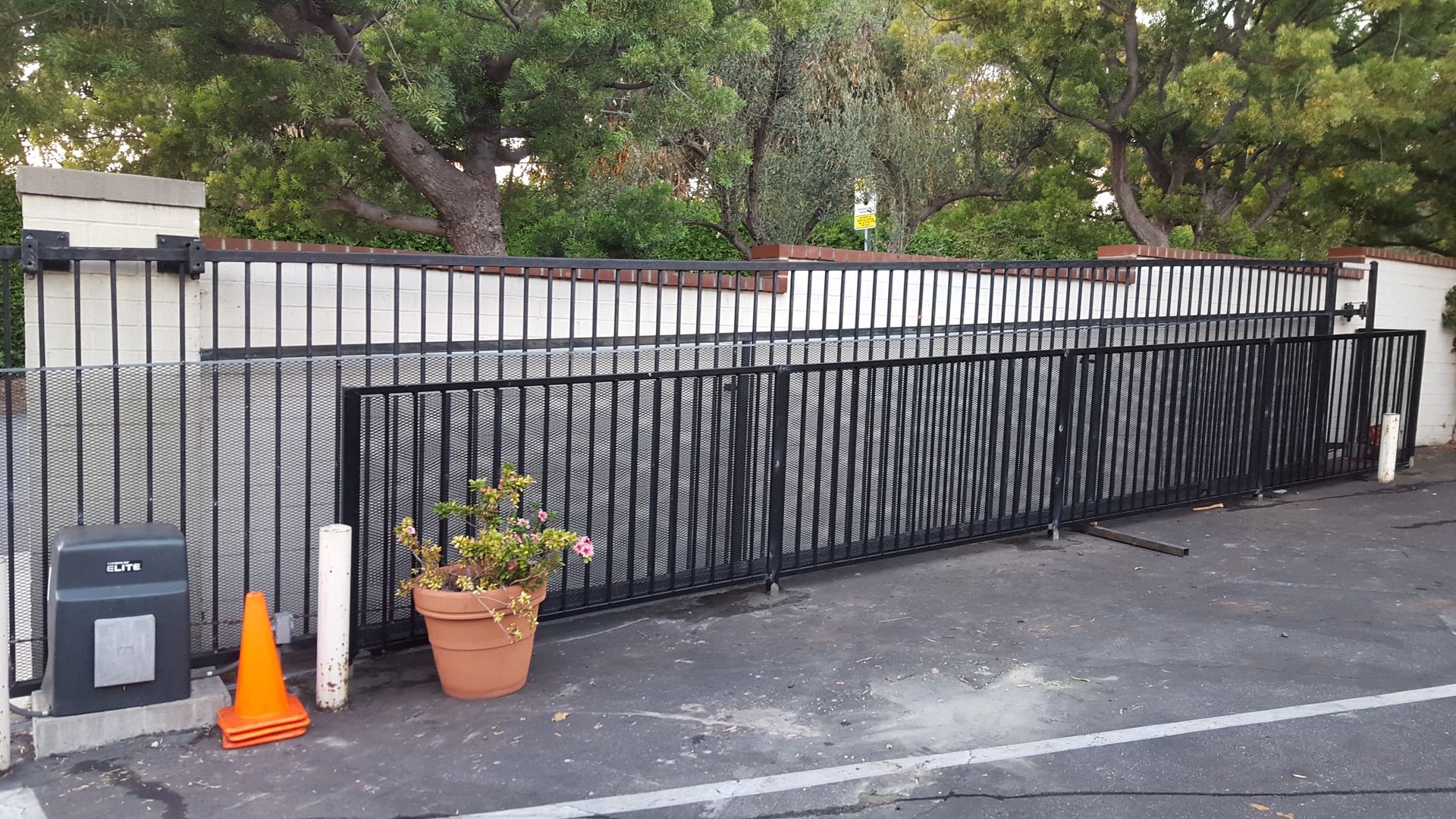 Black automatic security gate installed at a residential entrance