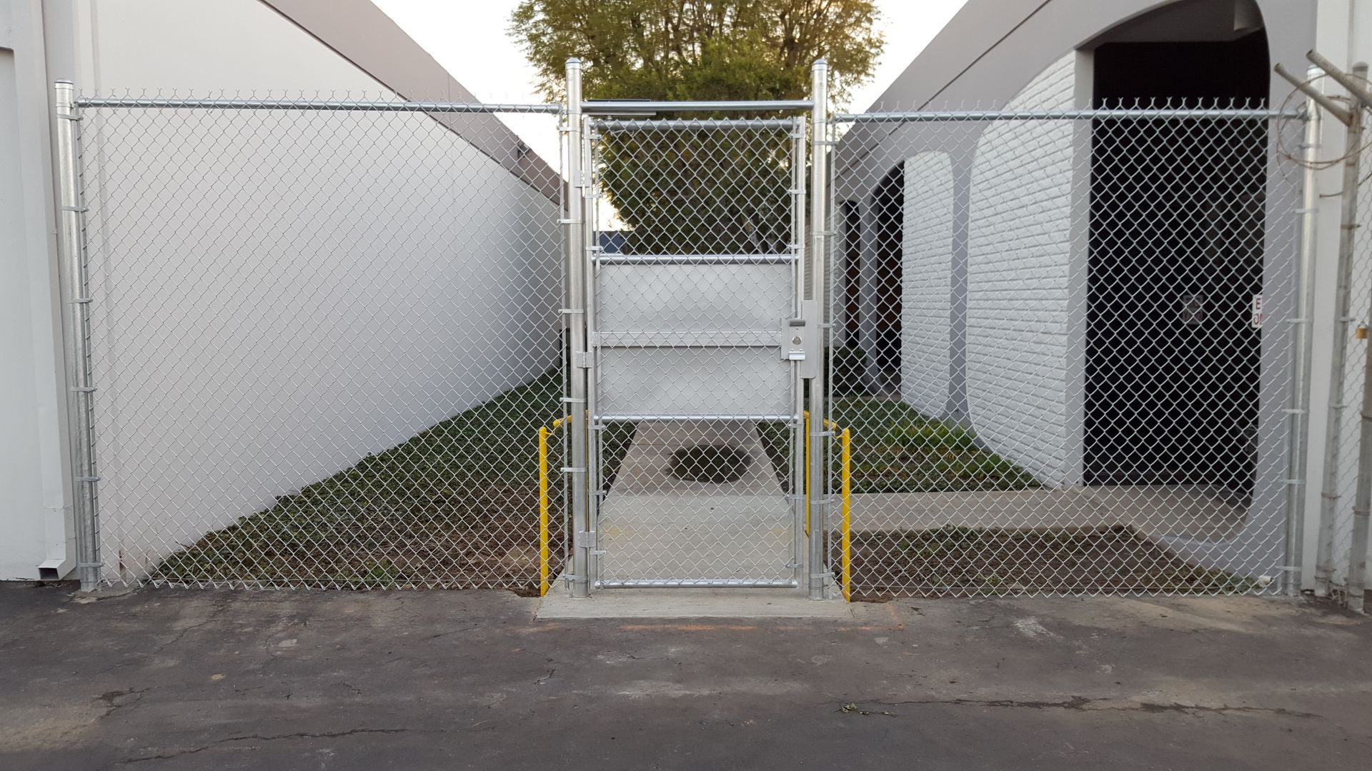 Chain-link fence with gate securing a residential driveway