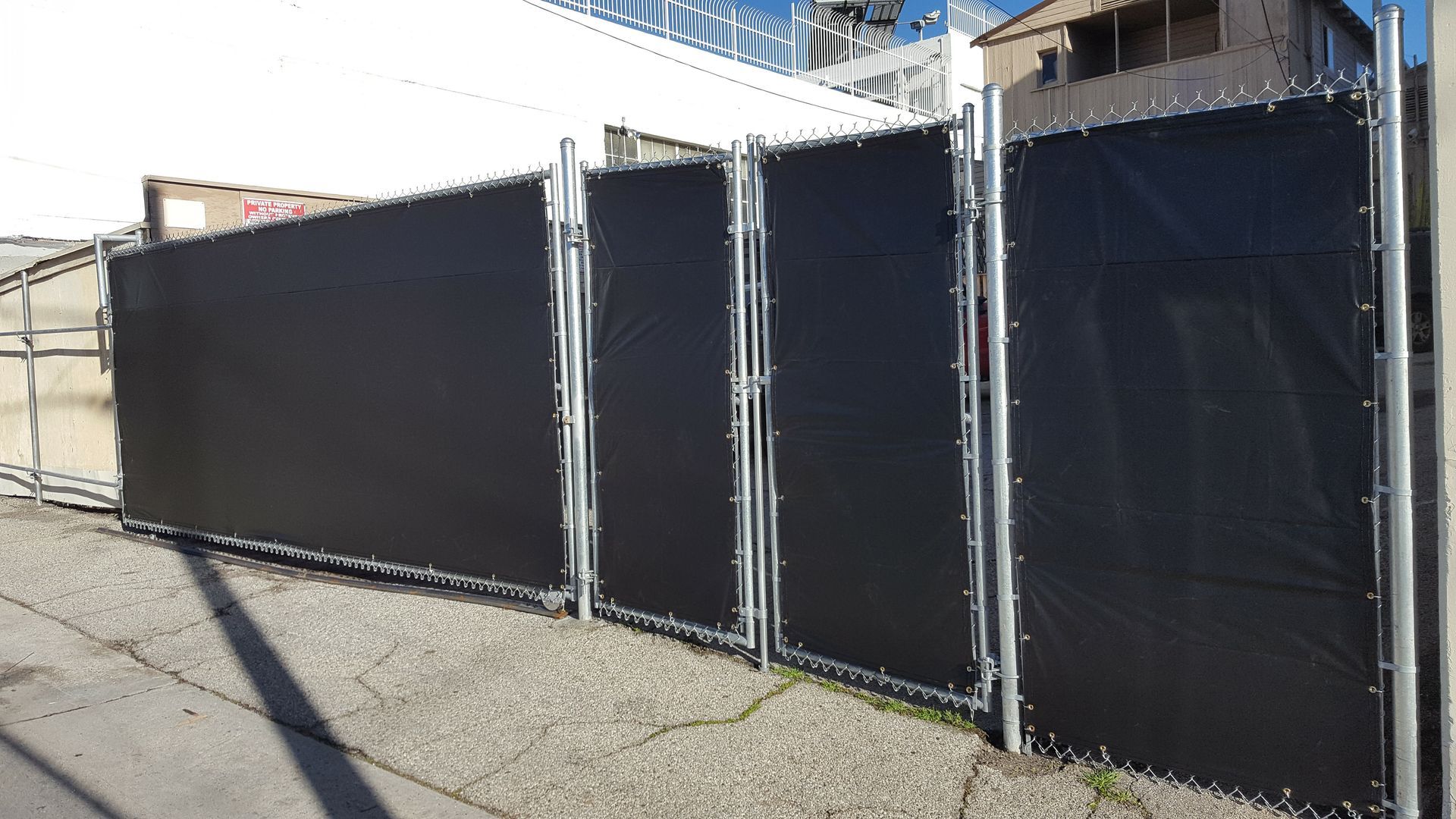 Chain-link fence with privacy slats along a property boundary