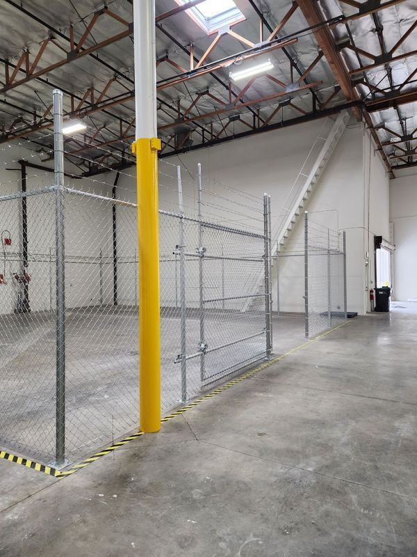 Interior chain-link fence with pole guard inside a warehouse facility