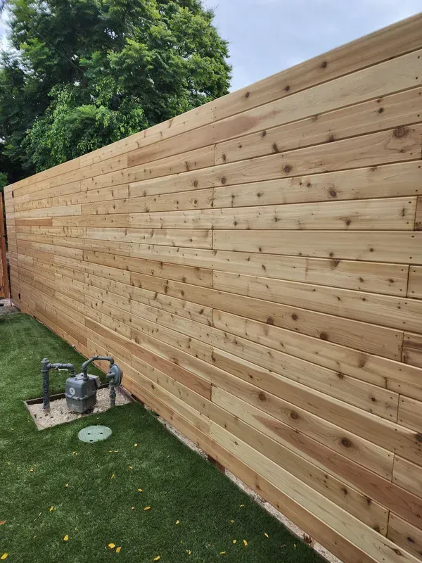Wood privacy fence installed around a residential utility area
