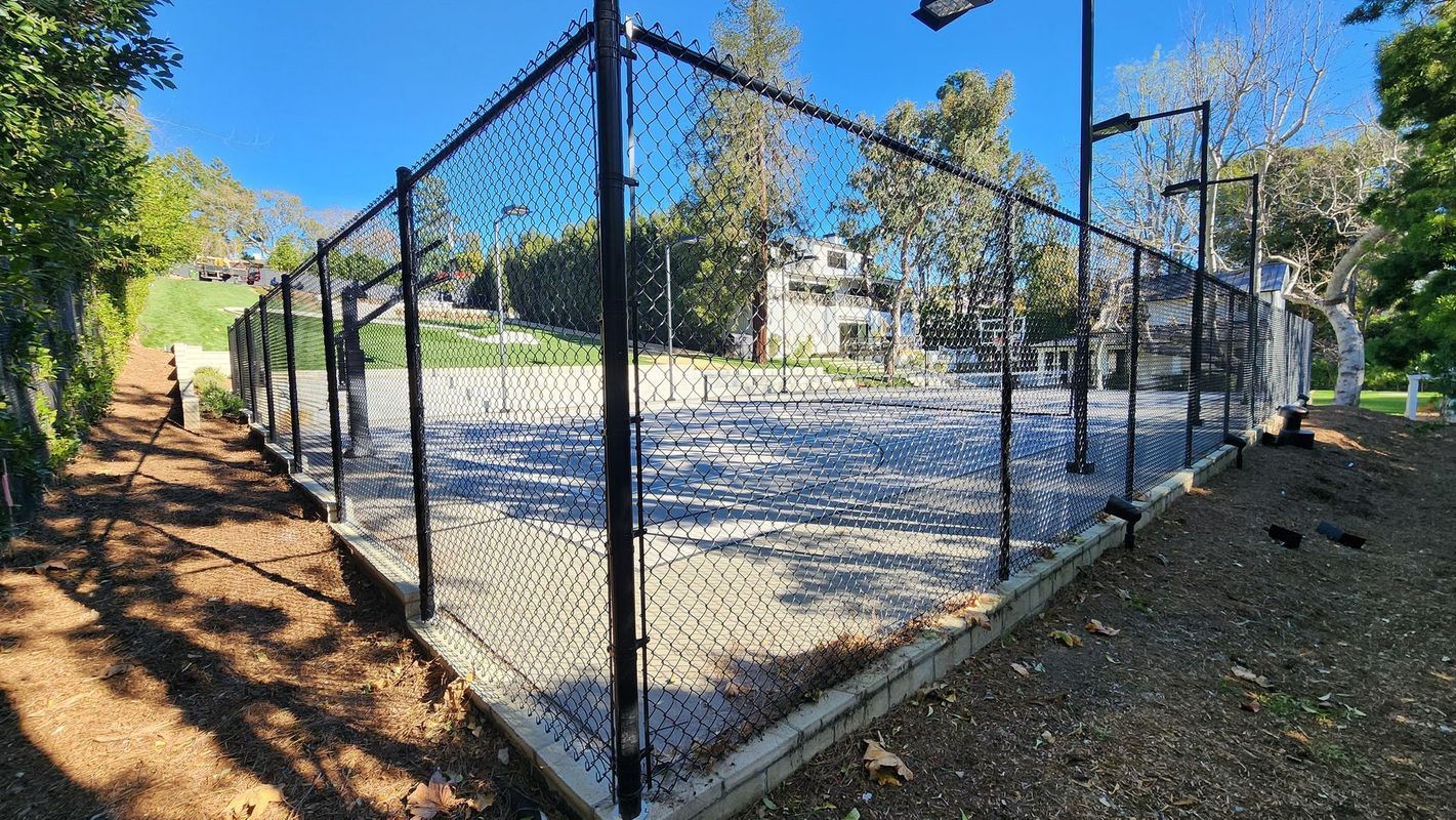 Black chain-link fence enclosing a Los Angeles tennis court