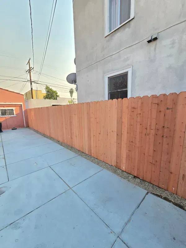 Stained wood fence enclosing a Los Angeles backyard patio