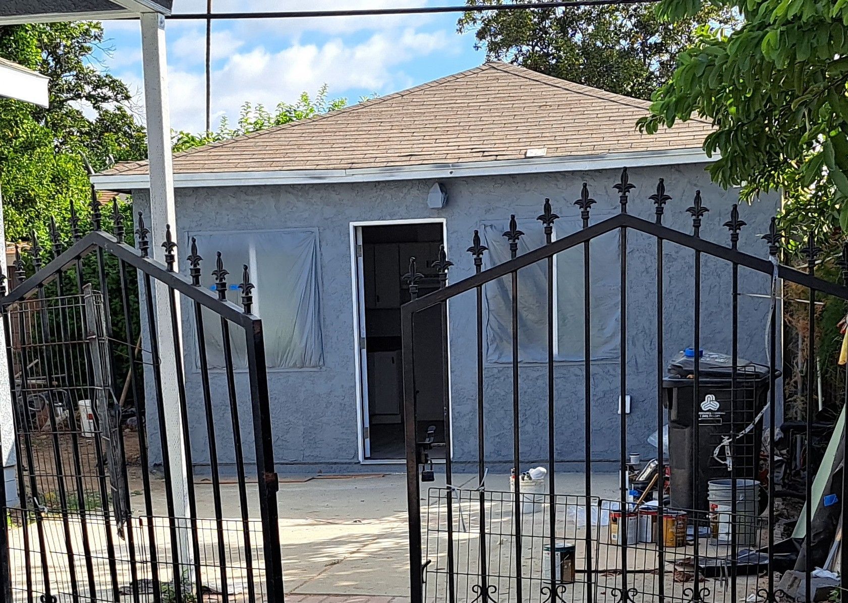 A small house with a wrought iron gate in front of it.