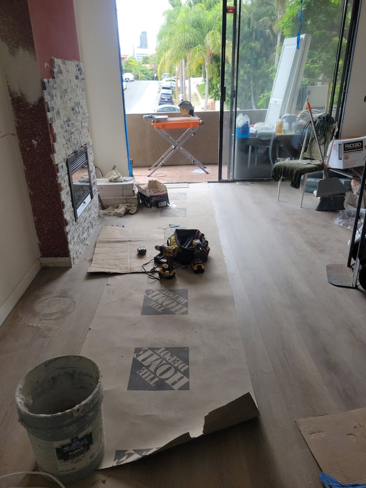 A room with a bucket and a piece of paper on the floor.