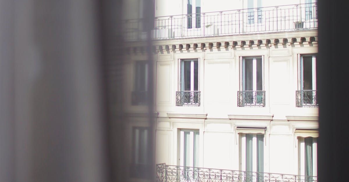 Une vue d'un bâtiment à travers une fenêtre avec balcon.