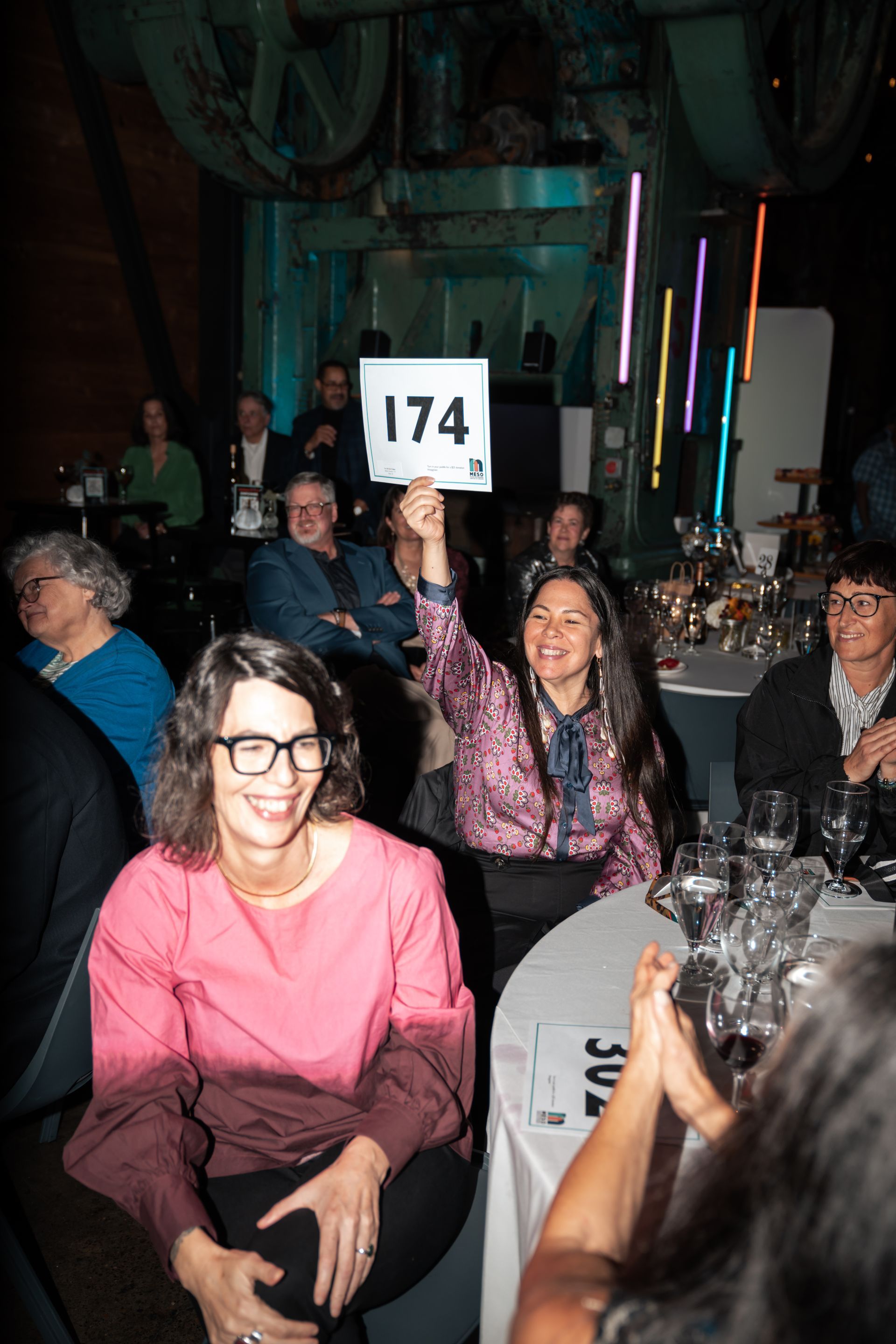 A woman is holding up a sign with the number 174 on it.