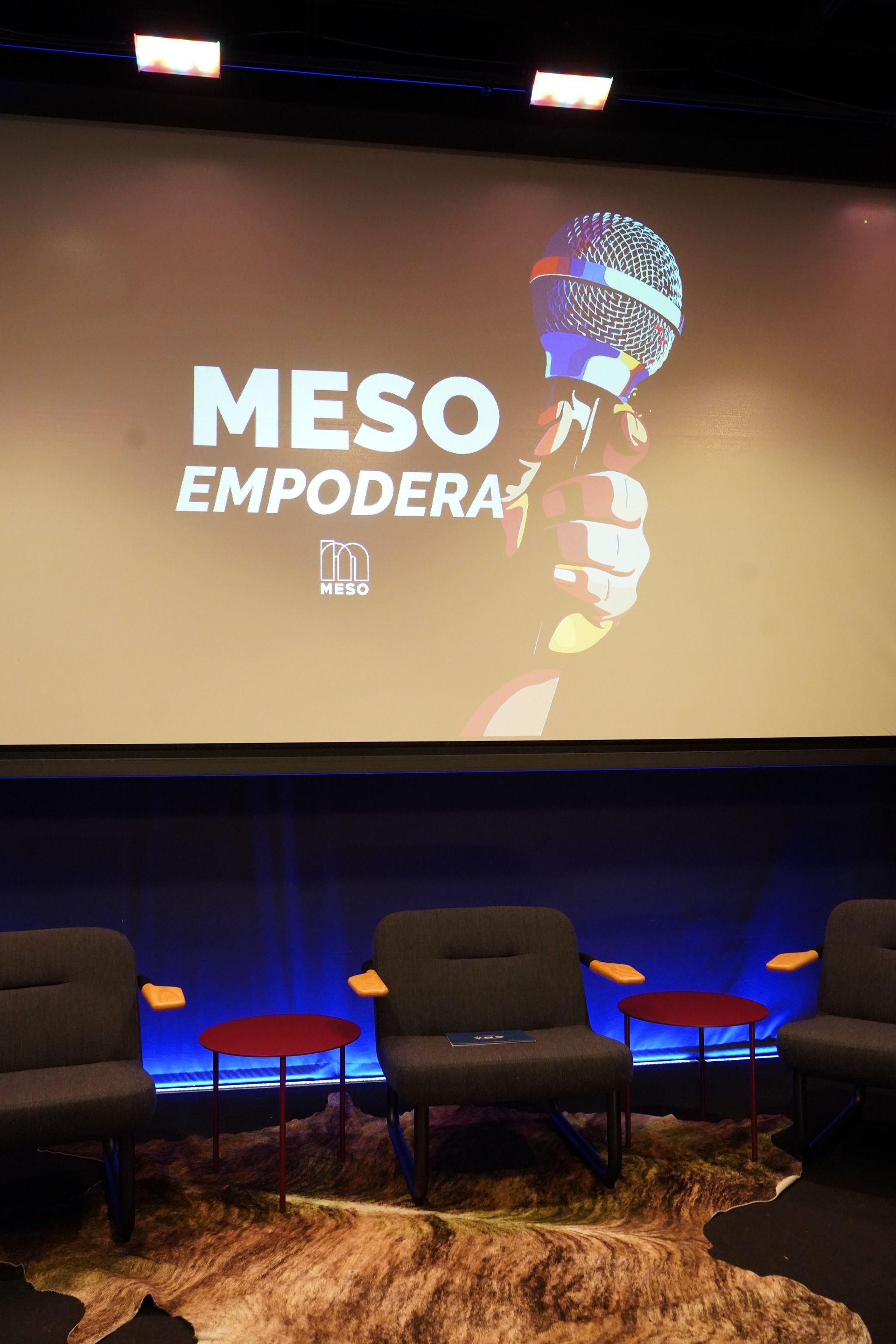 A room with chairs and a large screen that says meso empodera on it.