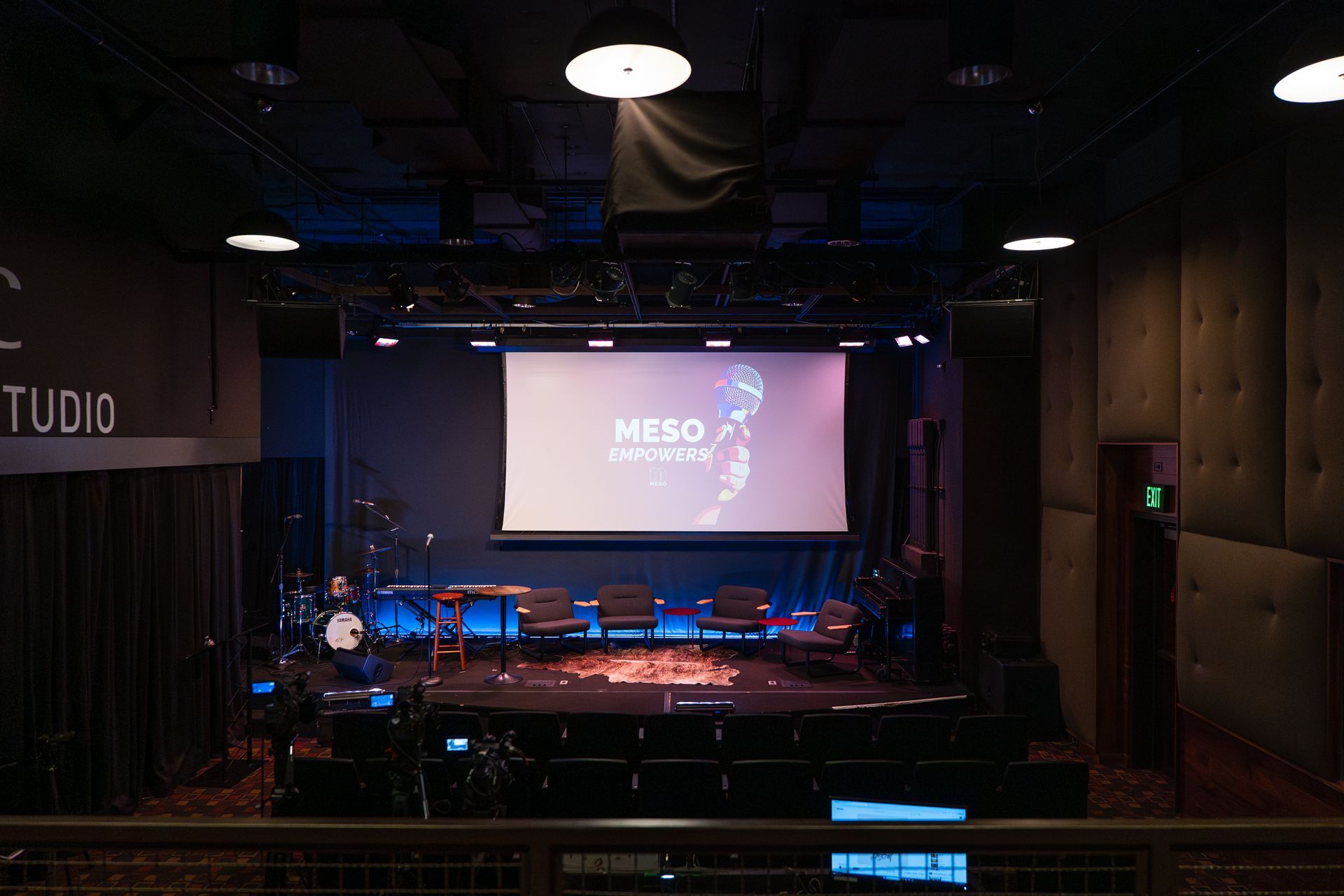 An empty stage with a projector screen in the middle of it.