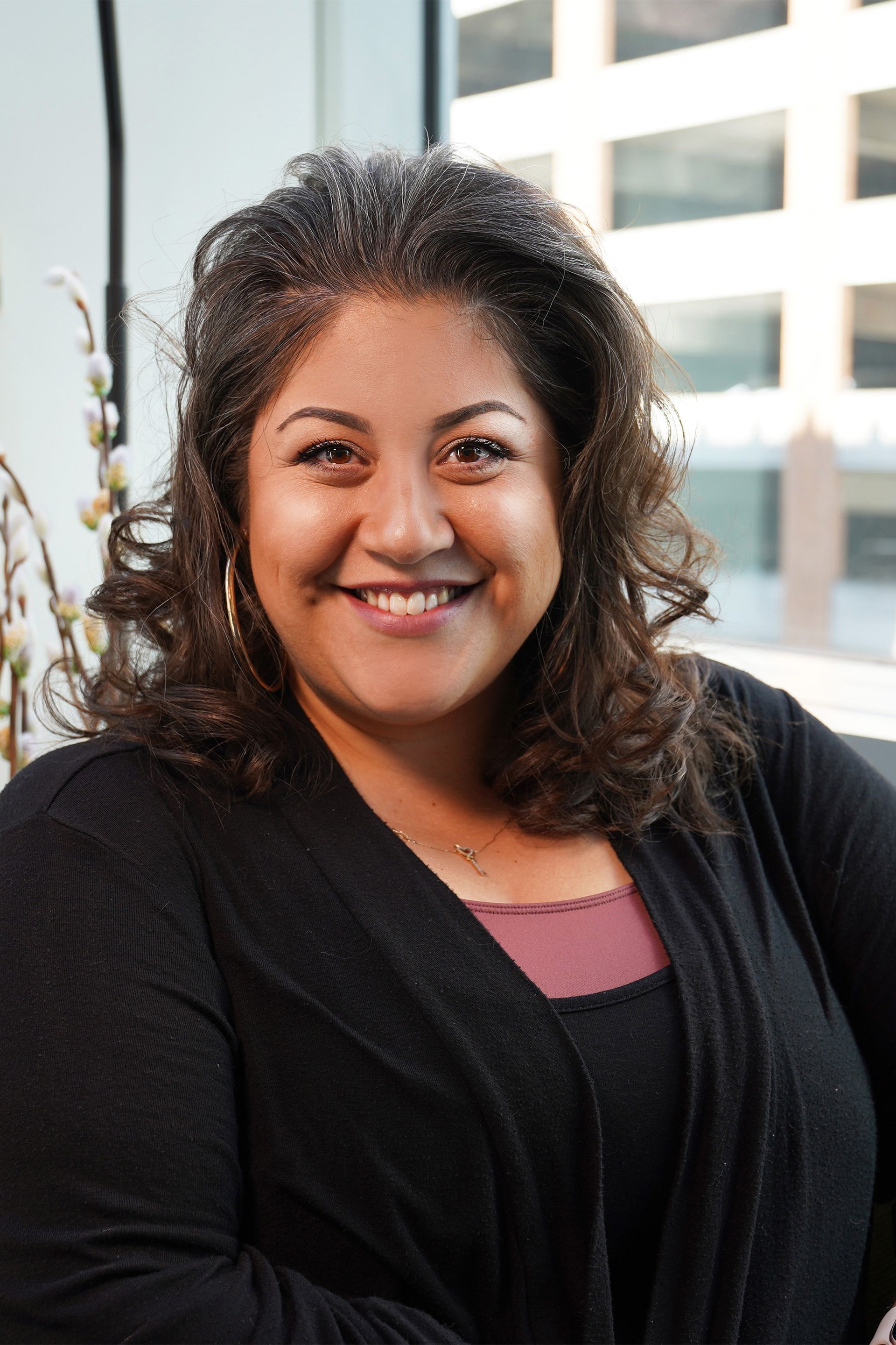A woman in a black sweater is smiling for the camera.
