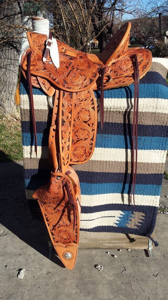 Orange patterned horse sculpture standing outdoors against a striped blanket backdrop