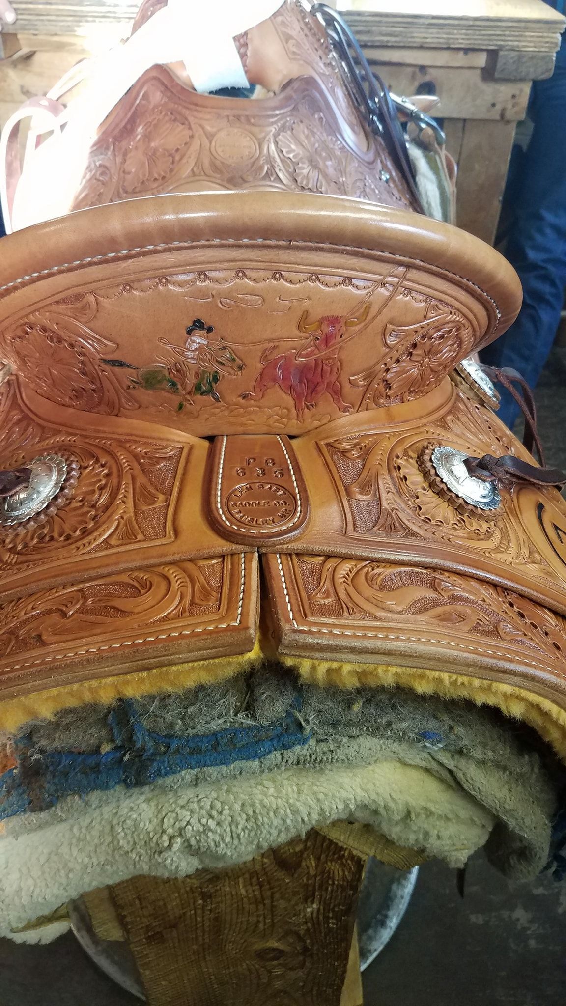 Decorative carved wooden chair back with ornate brown inlay and a worn blue cushion beneath