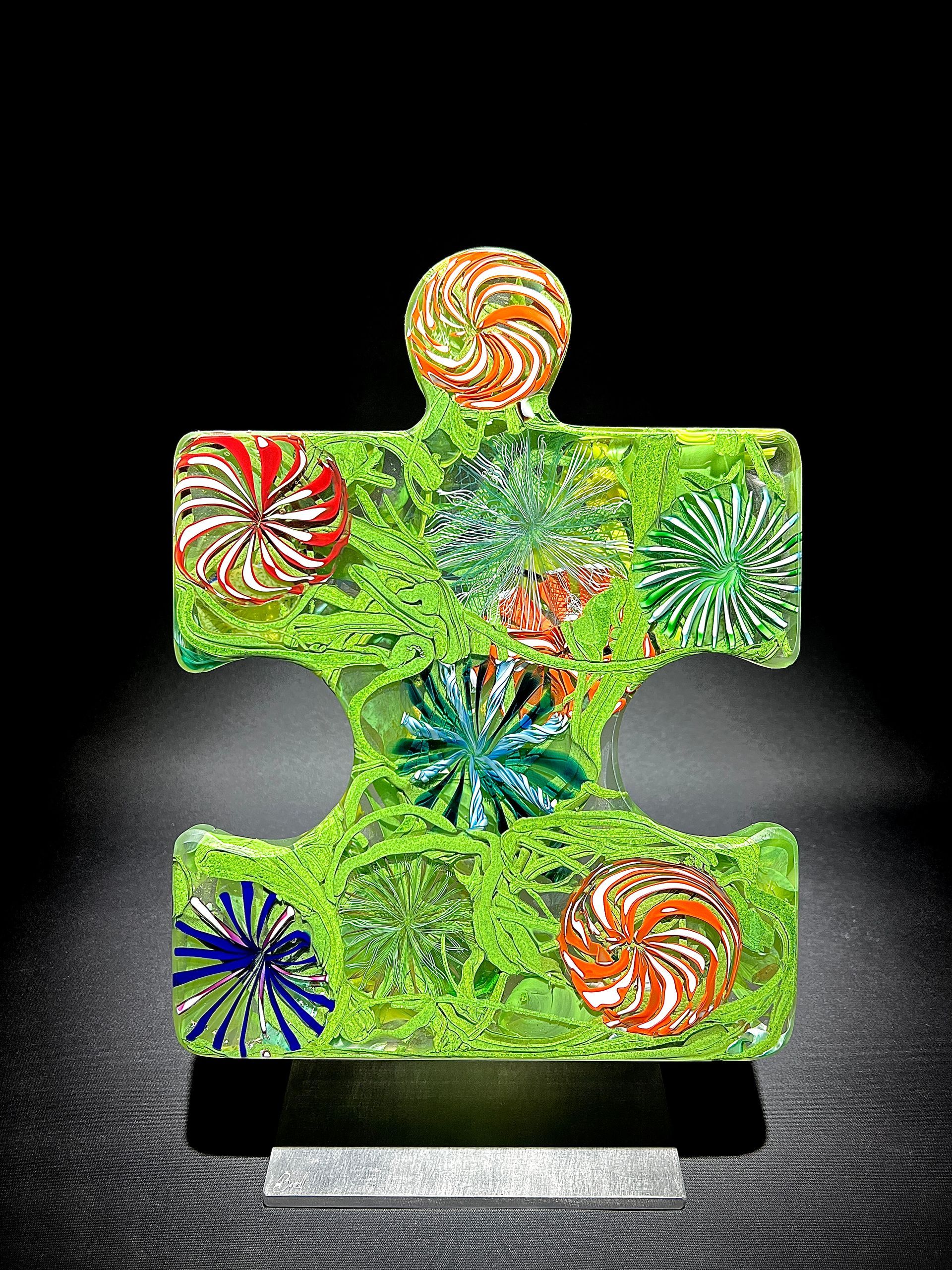 A green puzzle piece with flowers on it is on a stand.