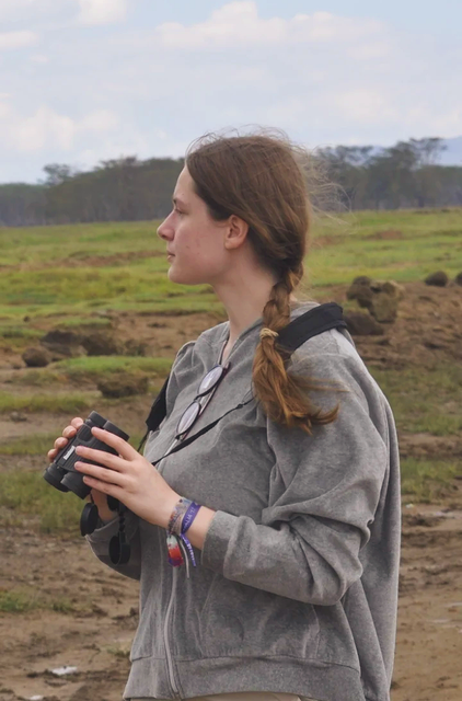 Laura Bornstein spotting wildlife with binoculars while on safari in Lake Nakuru National Park, Kenya