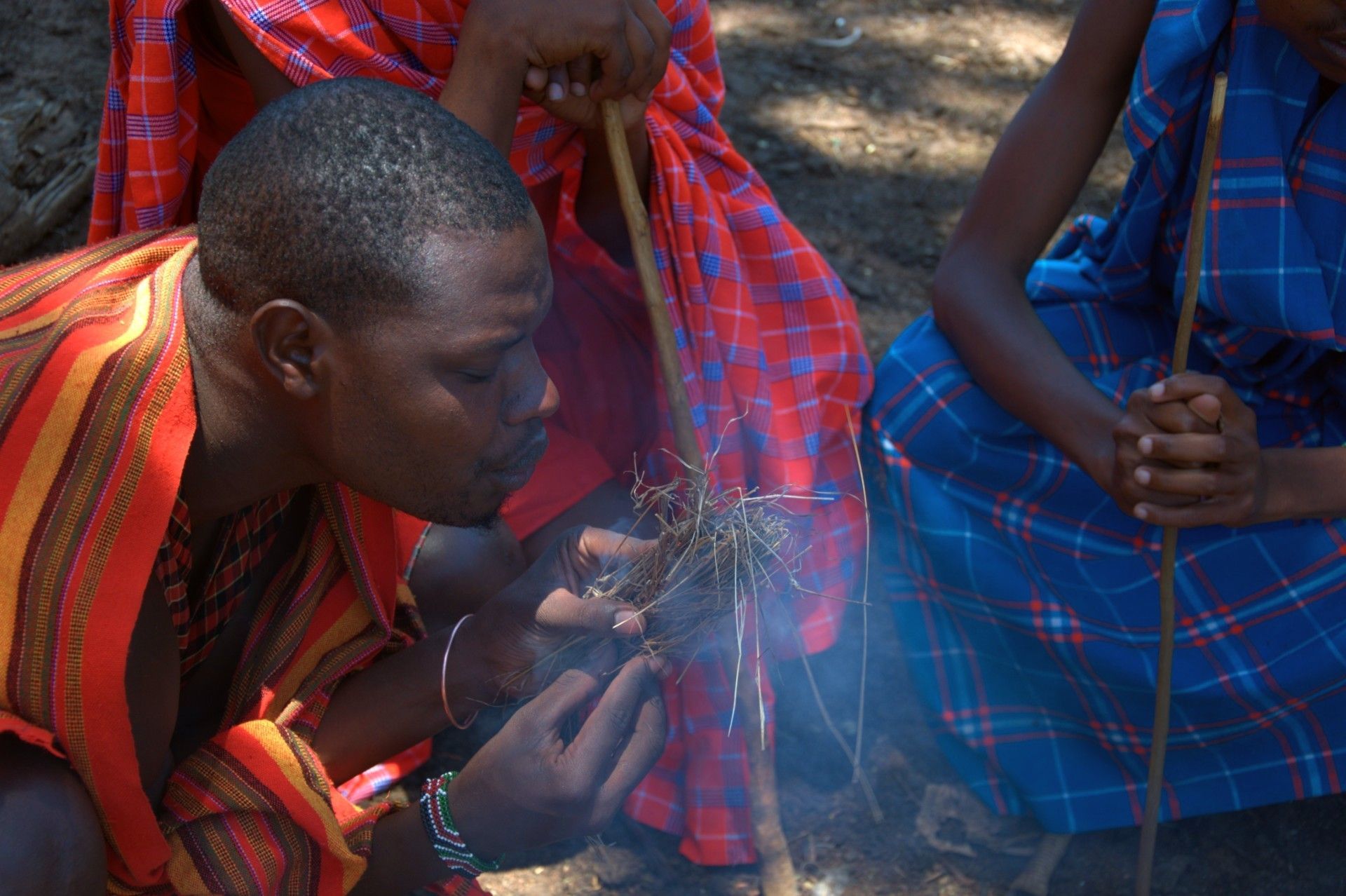 Maasai man making fire in his local village in the Maasai Mara, Kenya