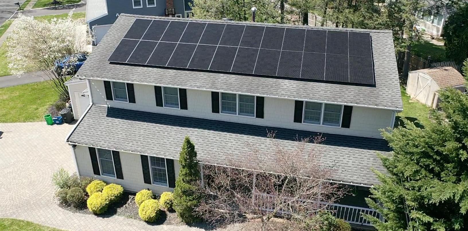 An aerial view of a house with solar panels on the roof.