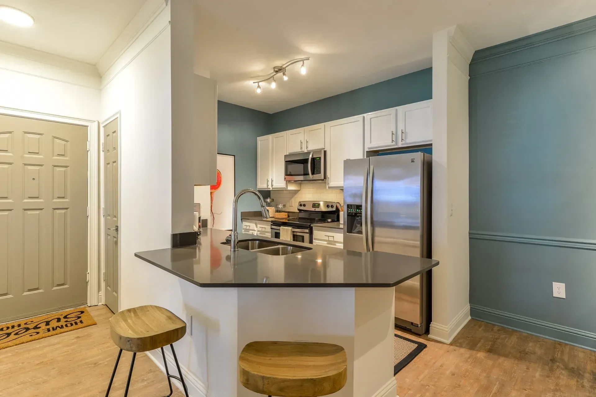 Modern kitchen with stainless steel appliances, granite countertops, and a breakfast bar.