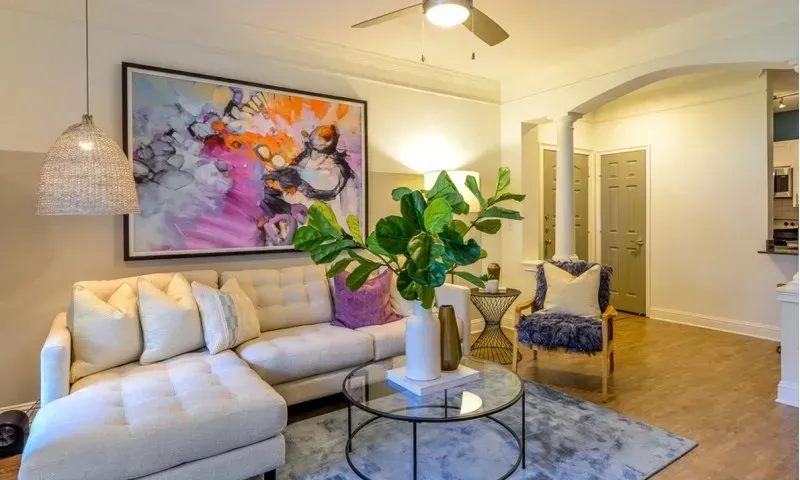 Living room with a large sectional sofa, abstract art, and a coffee table.