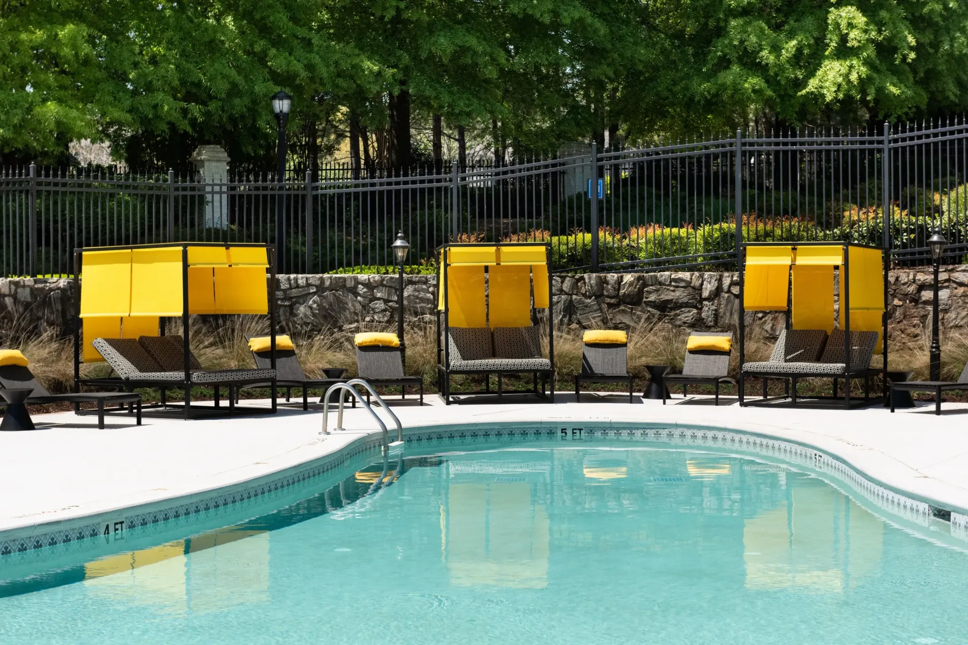 Outdoor swimming pool with lounge chairs and cabanas.