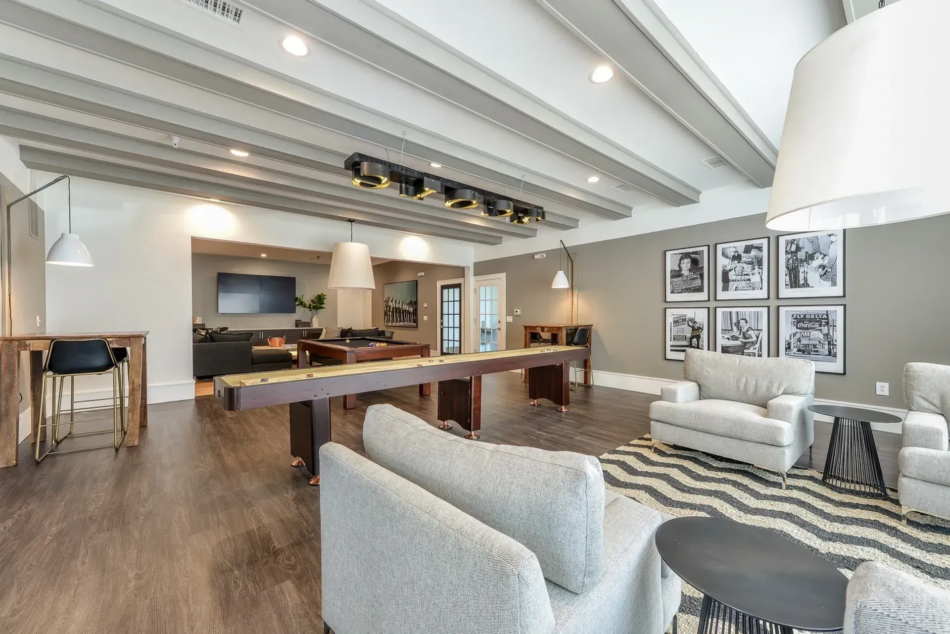 Community lounge area with shuffleboard table, seating, and decor.