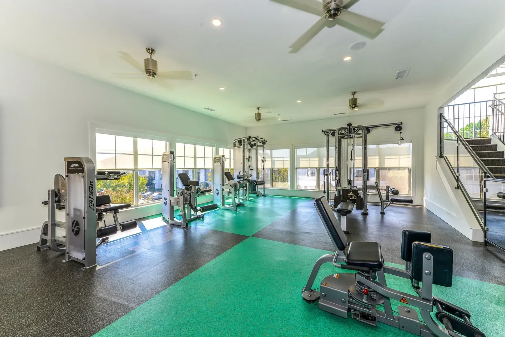 Gym with weight machines and large windows.
