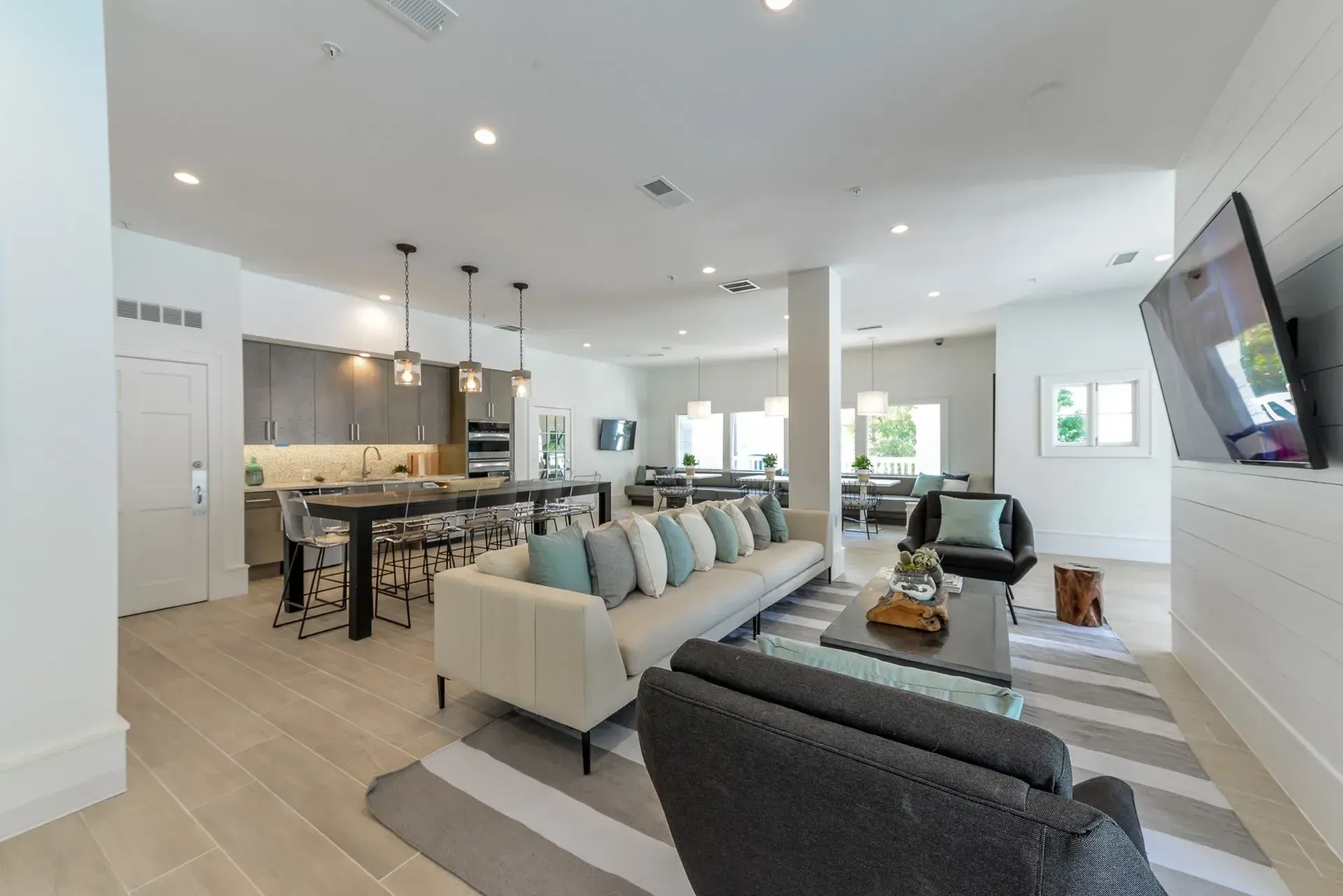 Community lounge area with kitchen, seating, and TV.