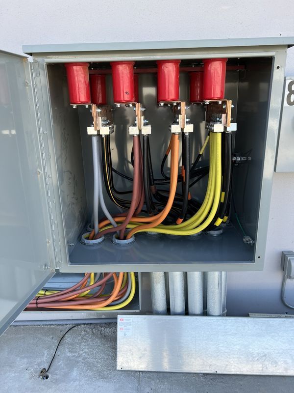Electrical cabinet with colored wires and red insulators.