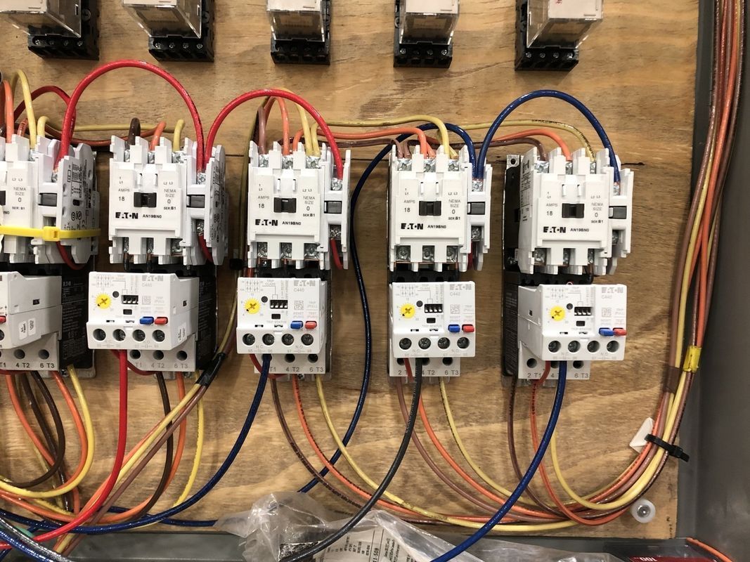 Electrical control panel with multiple relays and wiring.