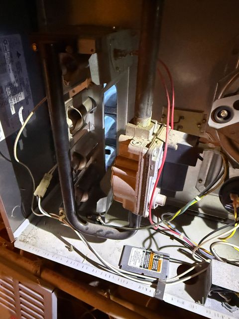 Interior of an open electronics cabinet with exposed wiring, circuit boards, and components inside a dim enclosure