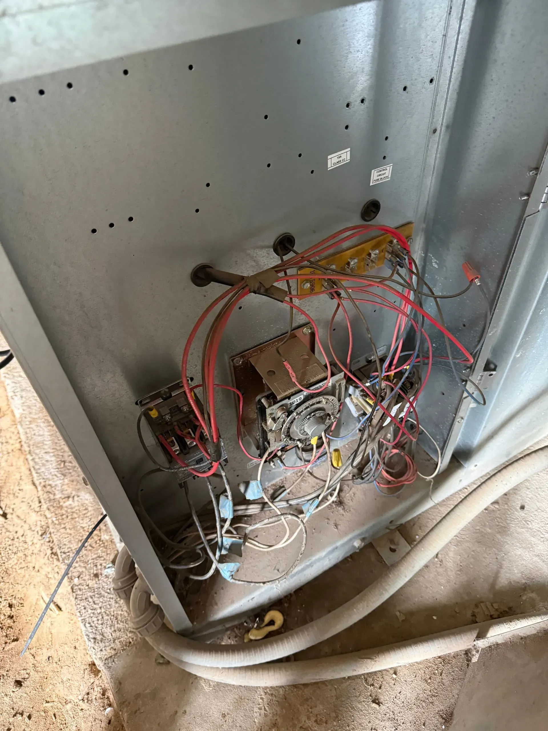 Electrical panel with exposed wiring and components inside a metal cabinet