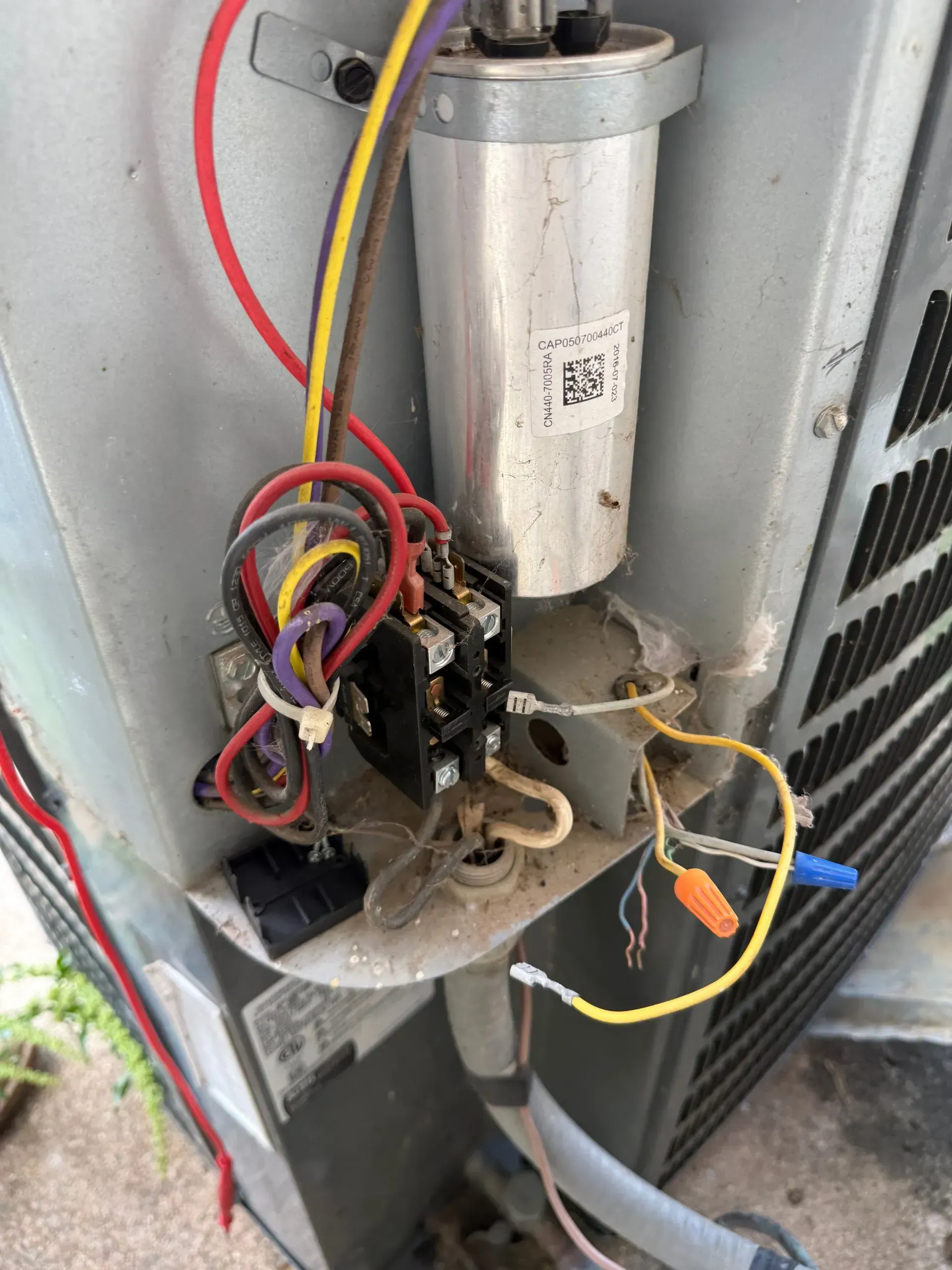 Open electrical component with exposed wires inside an outdoor HVAC unit