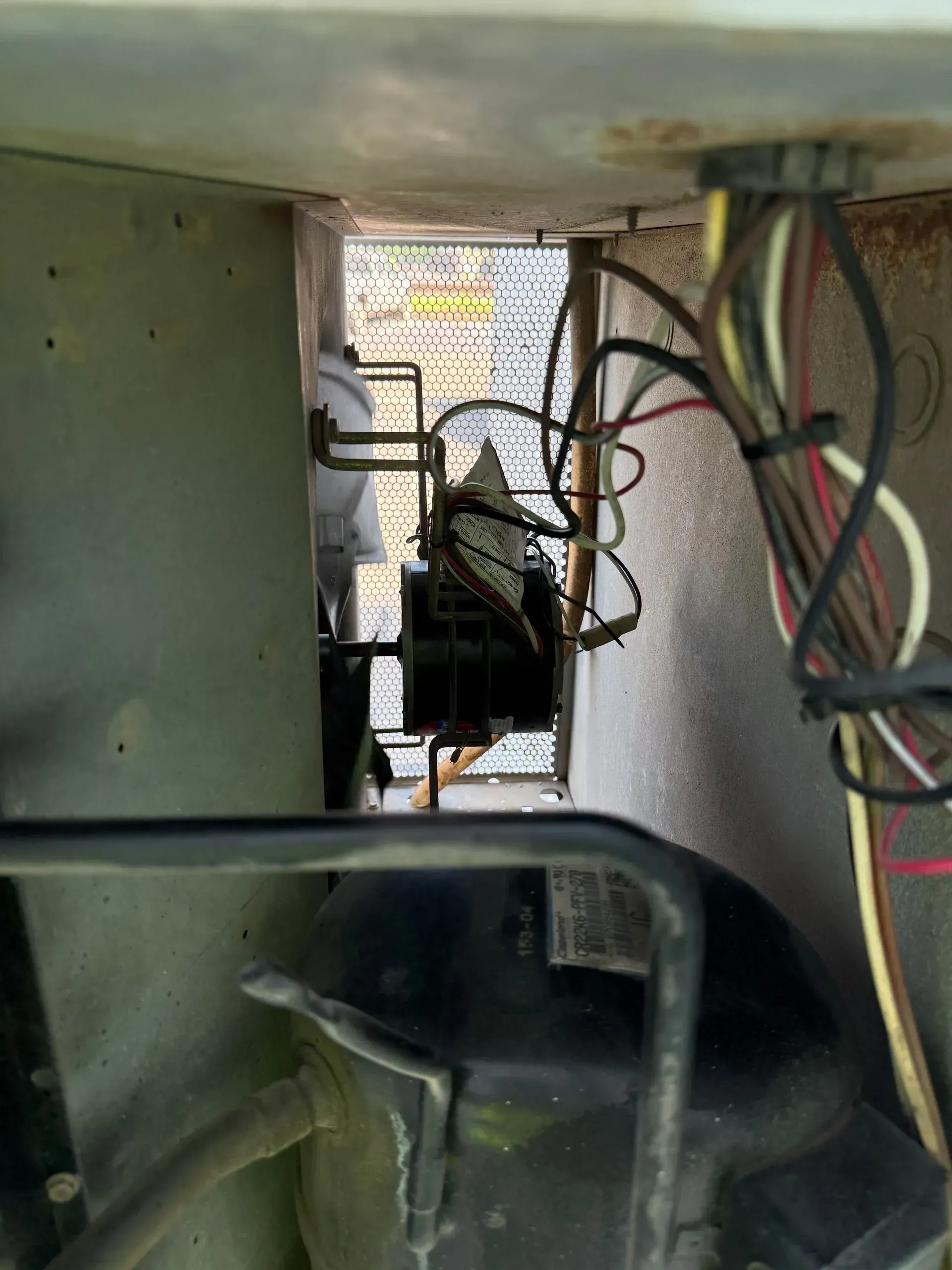 Interior of a metal appliance with exposed wiring and a small fan or motor assembly.