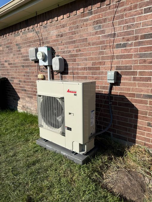Exterior air conditioning unit mounted on pad with visible power and refrigerant lines