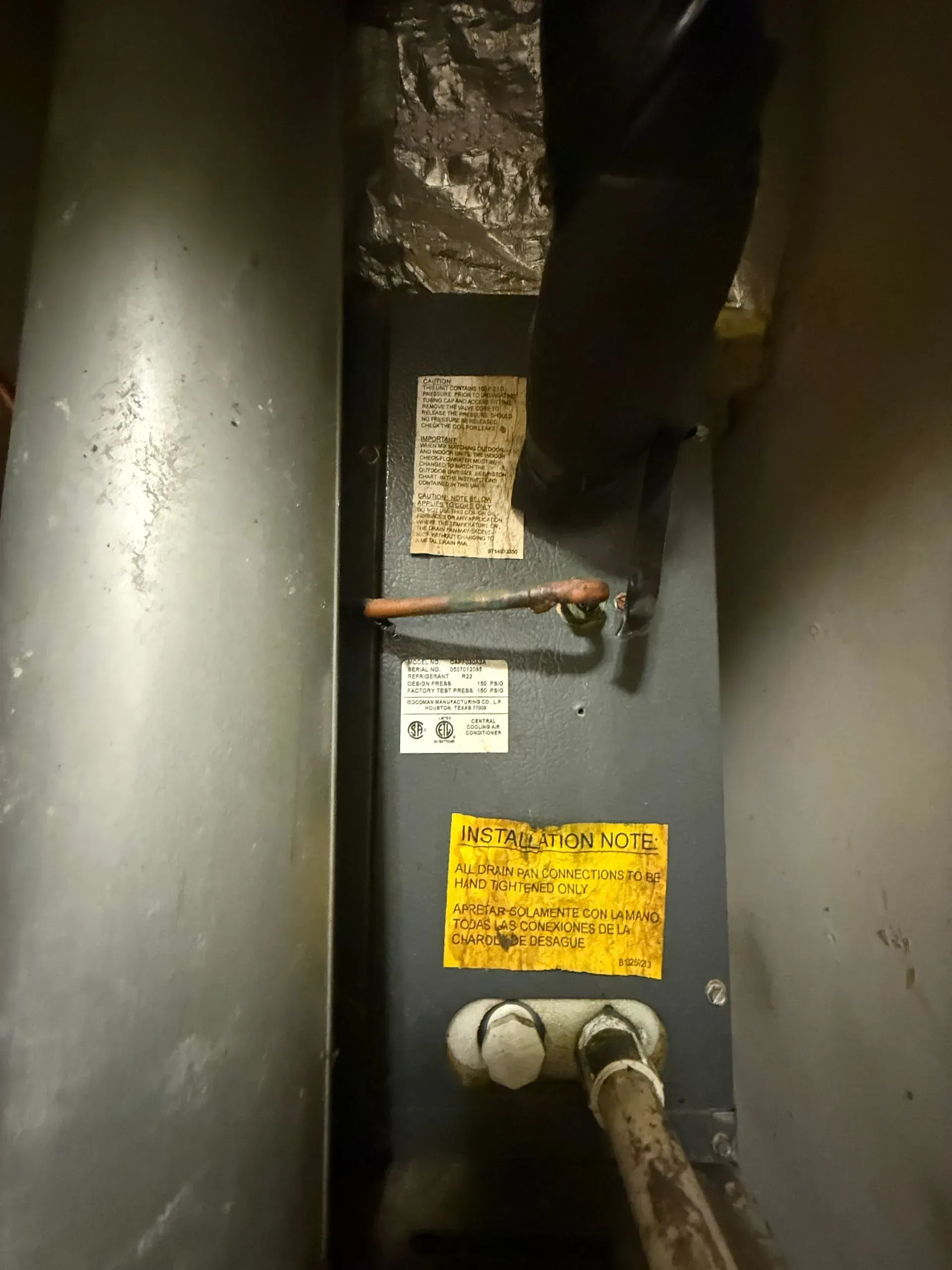Utility meter in a narrow space, with pipes, labels, and a hand turning a valve.