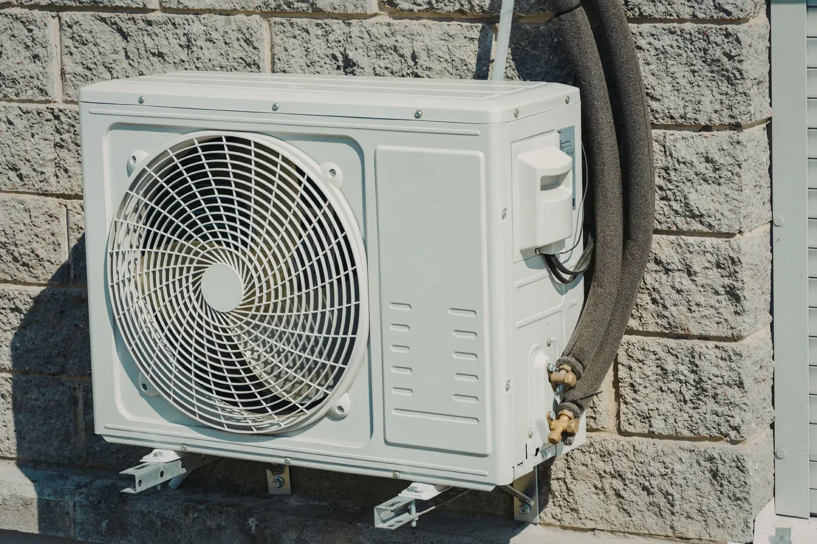 Rooftop HVAC units on a flat commercial roof beside a brick building and tall hotel tower