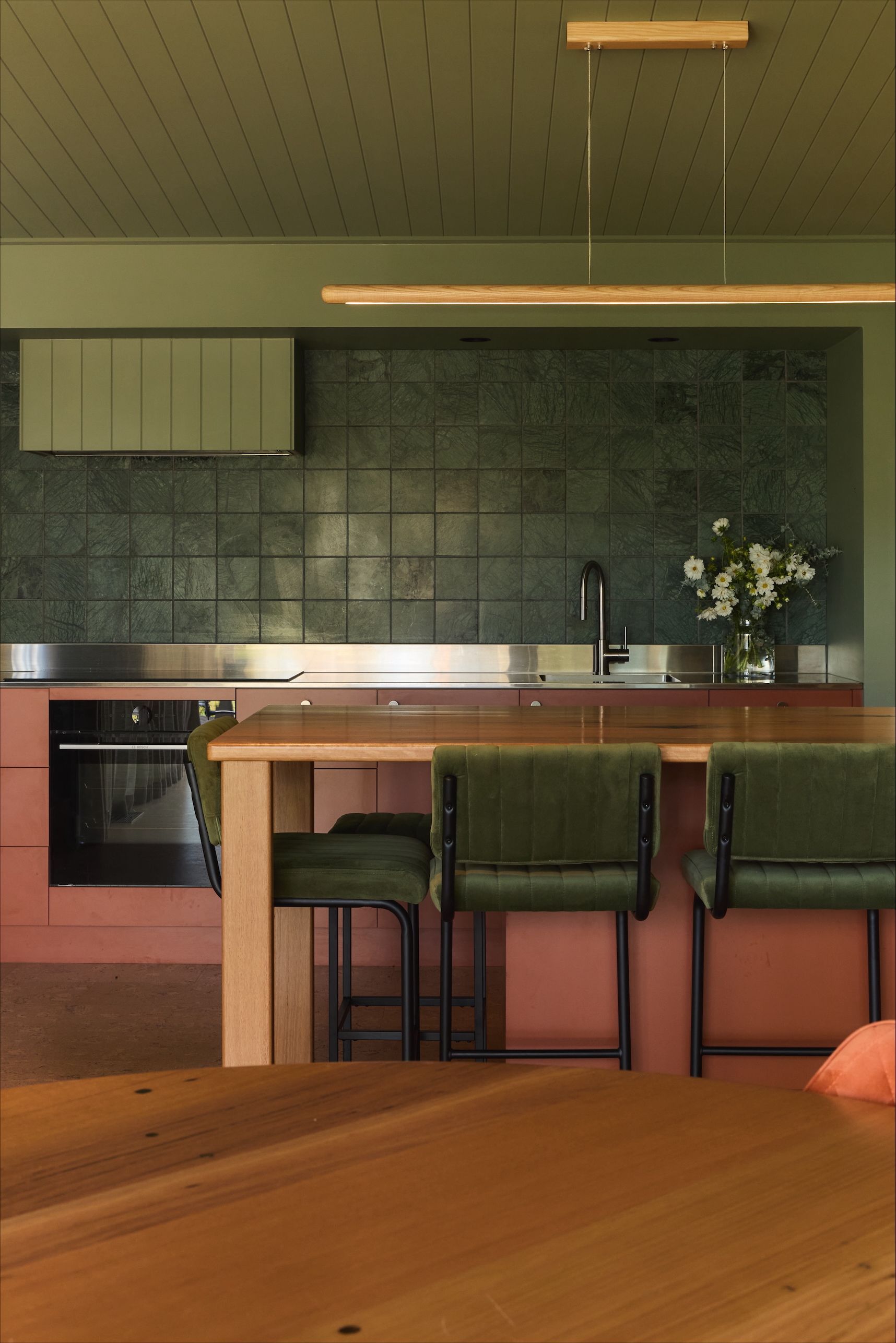 Green stone tiled splashback & terracotta kitchen