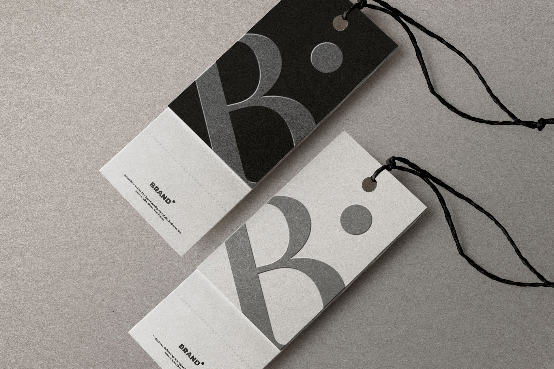 Two rectangular clothing tags with the letter