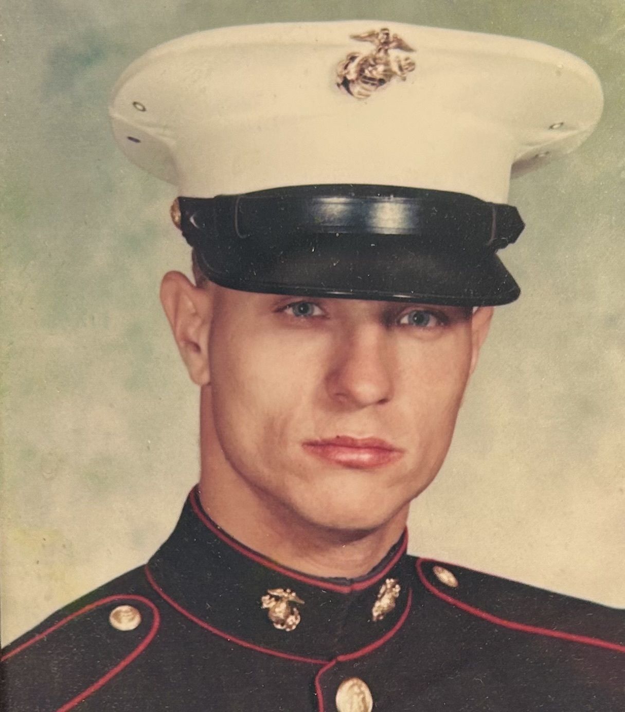 Man in Marine uniform and hat, looking forward.